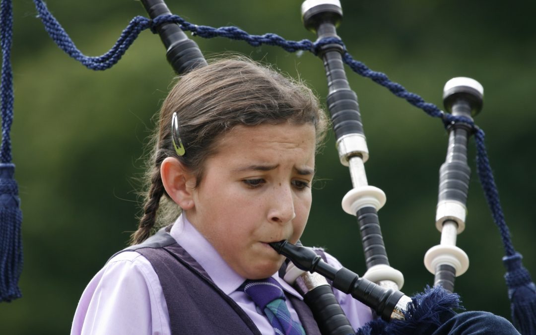 girl pretending to enjoy playing the bagpipes