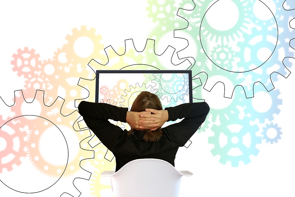 Woman looking at screen surrounded by gears