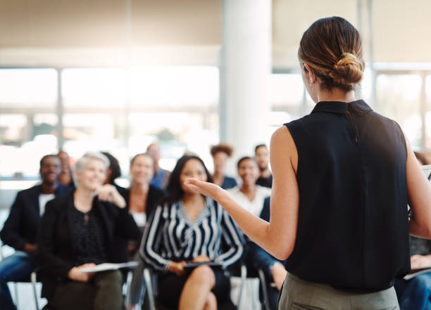 Woman speaking to a crowd of people.