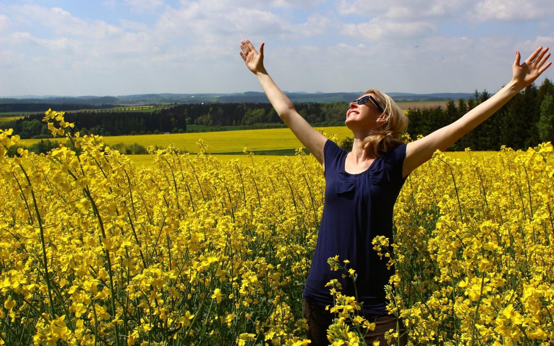 Woman running through field of yellow flowers