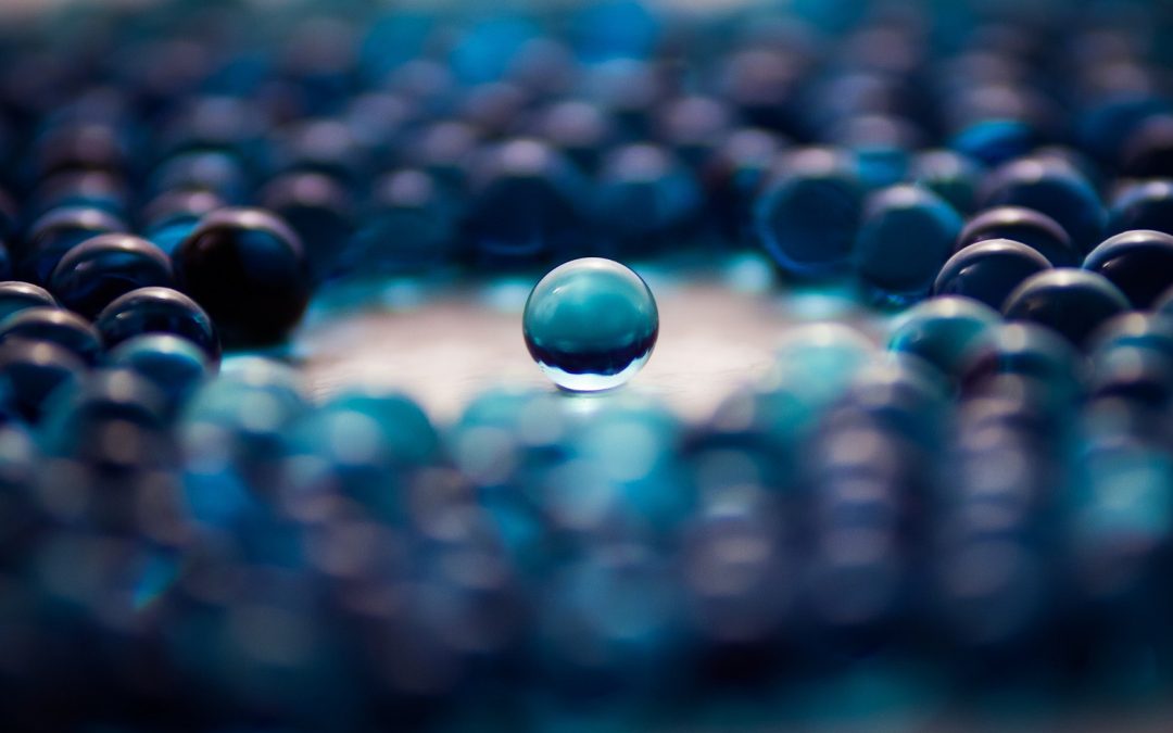 Group of marbles with one separated in the middle.